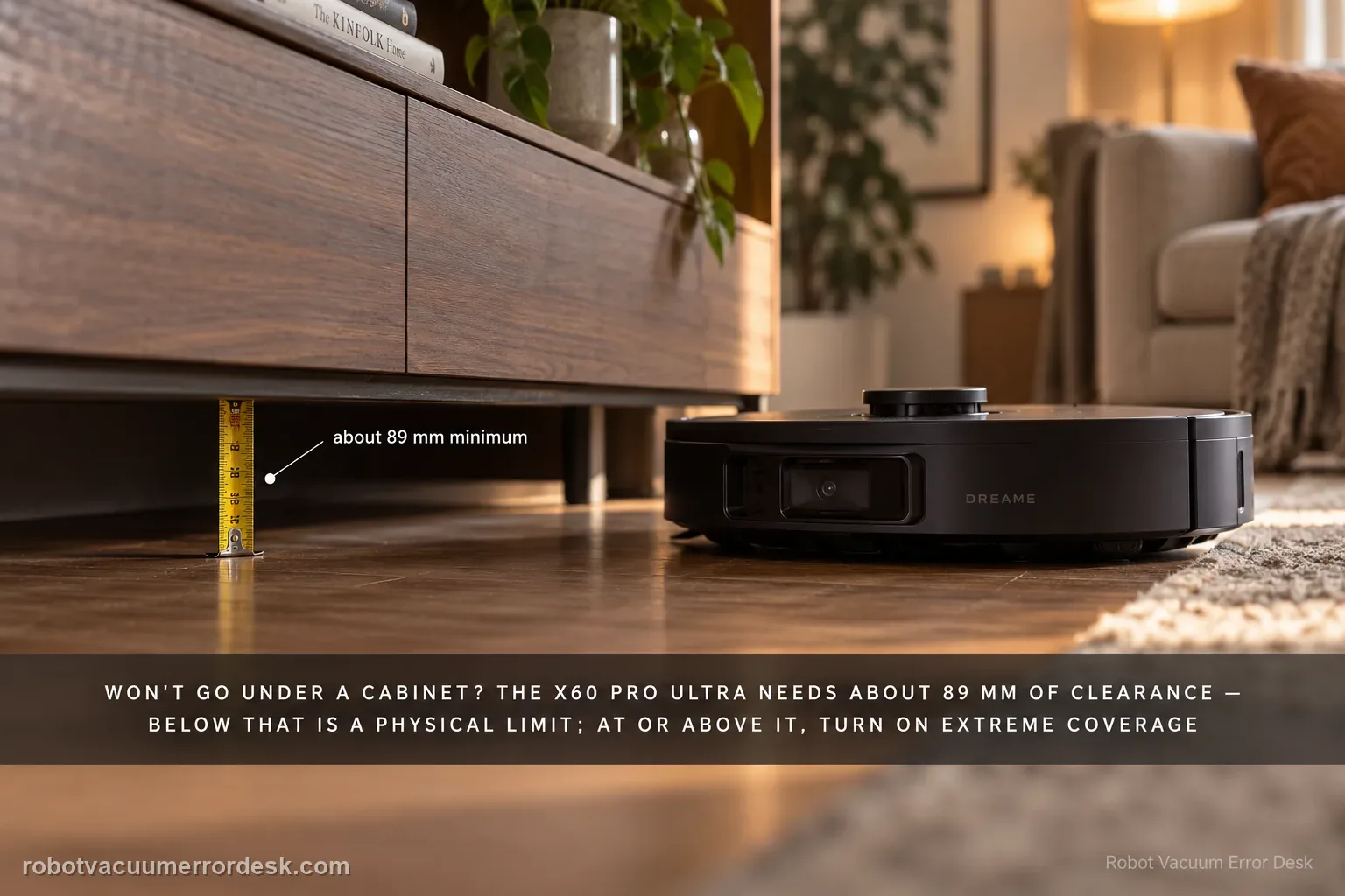 A small tape measure standing in the gap beneath a low media console showing the clearance height, a Dreame X60 Pro Ultra waiting just outside the opening.