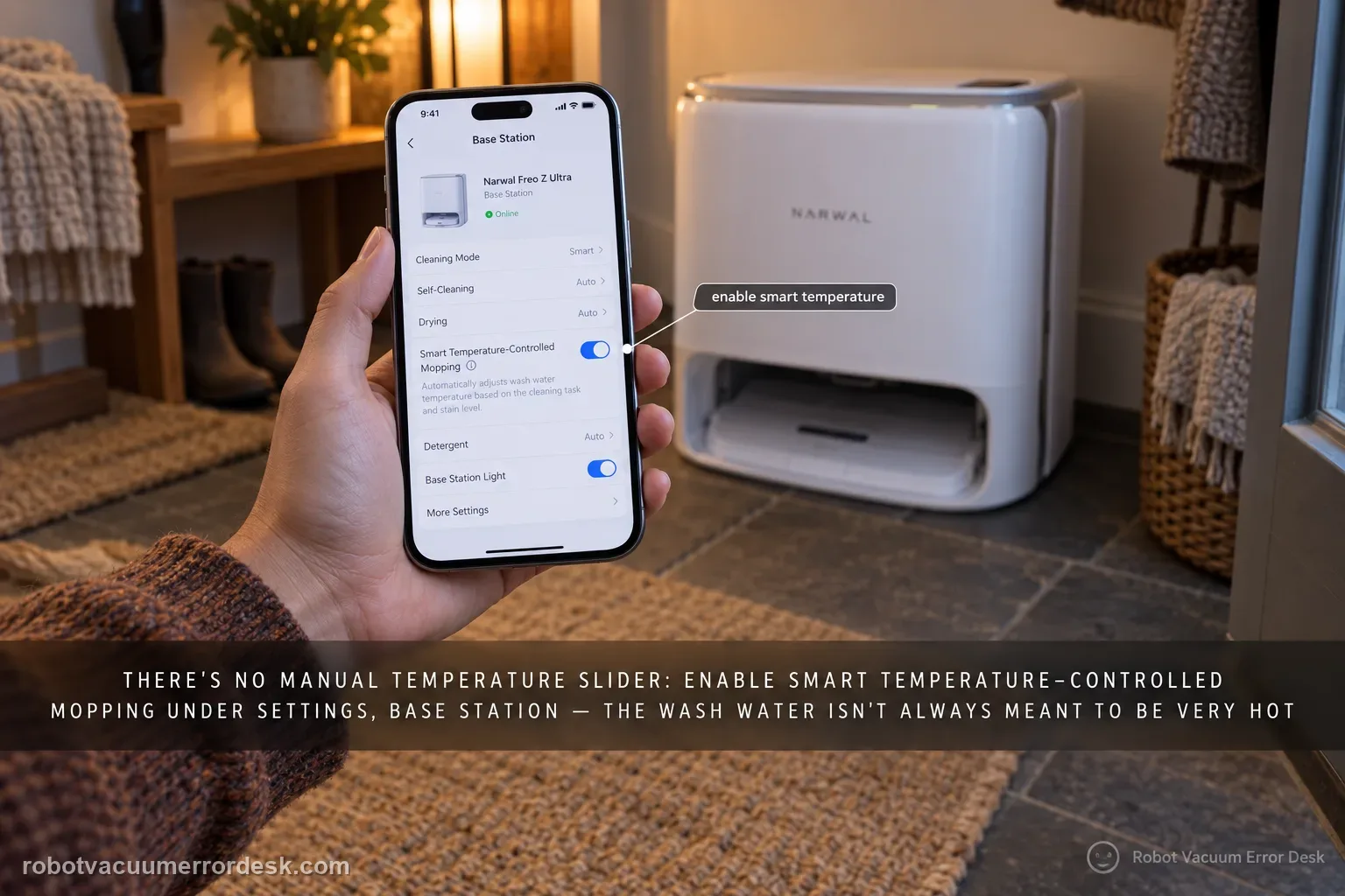 A hand holding a phone showing the Narwal app Base Station settings beside a Freo Z Ultra base in warm lamp light.