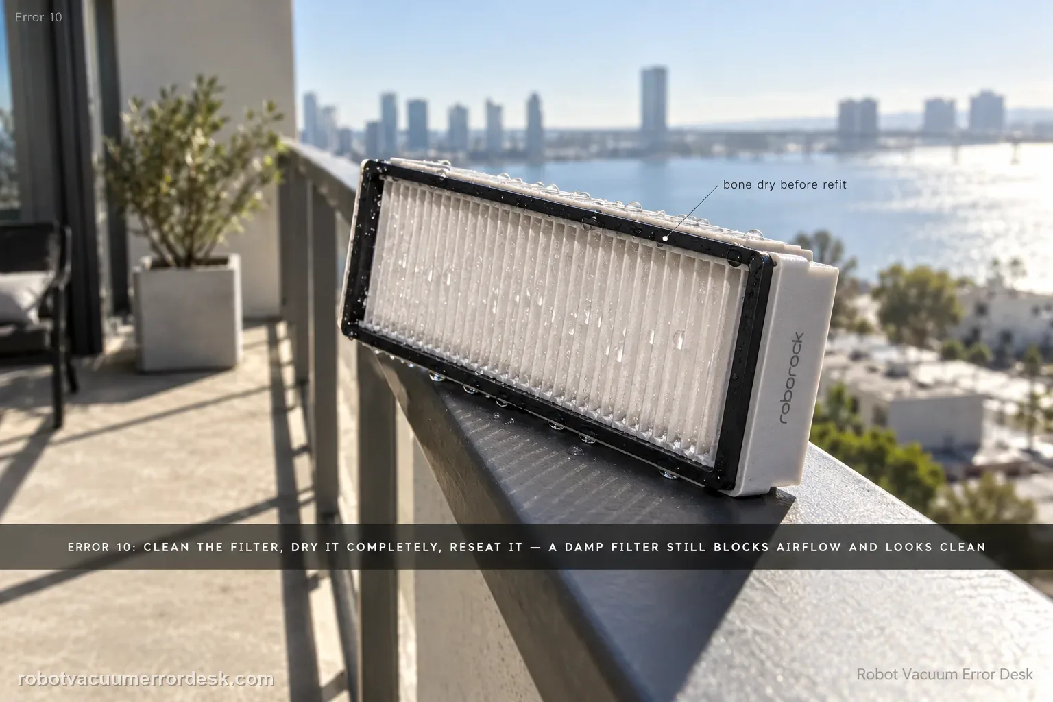 A Roborock Saros 20 Sonic filter propped on a sunlit balcony rail to dry, water still beading on the pleats, Error 10 tagged in the corner.