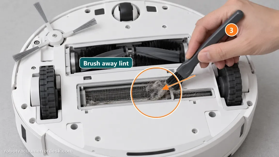 Soft cleaning brush lifts visible lint from the suction-port filter on the powered-off robot underside; the debris and brush tip are ringed and pointed out.