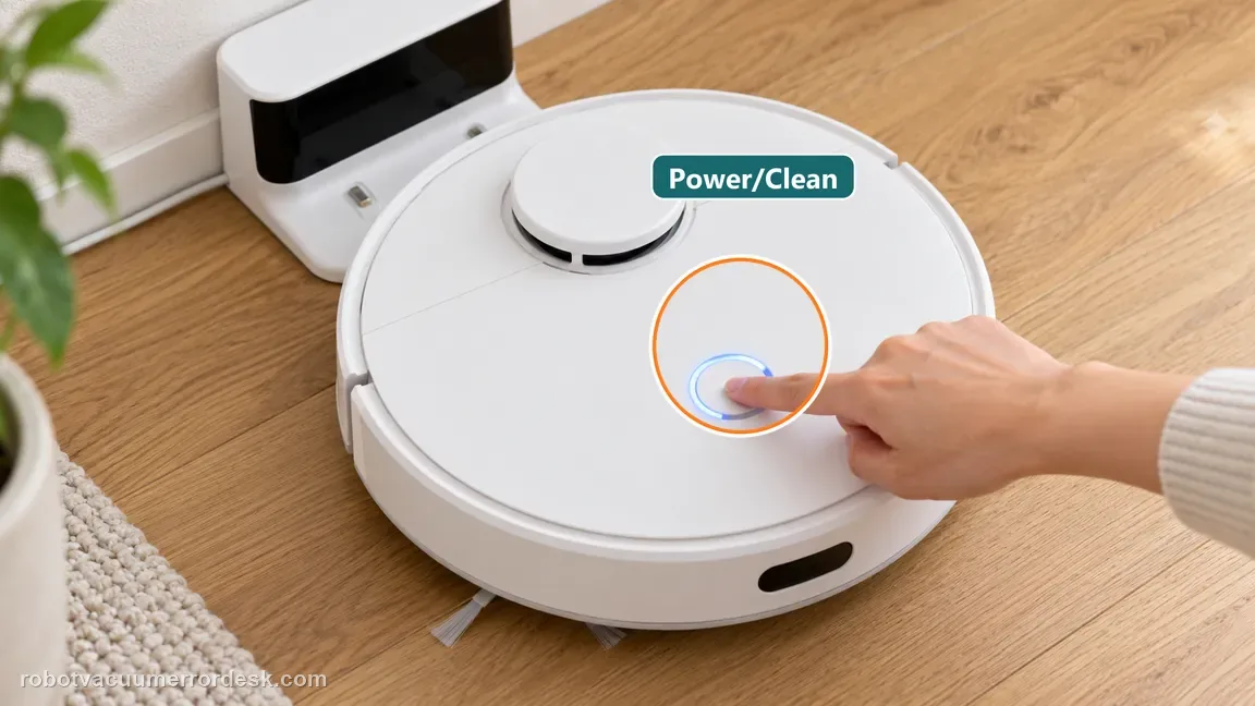 A finger presses the blue-lit Power/Clean control on a white robot vacuum.